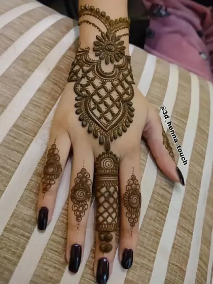 A beautiful jewelry-style design for the back of the hand. The central pendant-like motif and detailed finger work are very elegant.