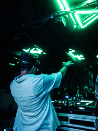 Dropping beats under the green neon lights. A cool, atmospheric shot from a Friday night gig in Mumbai.