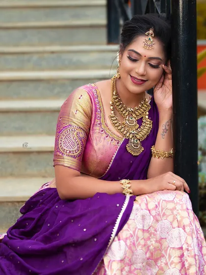 This candid shot captures the elegance of the temple jewellery, including the choker, haram, and maang tikka, against a purple and pink half-saree.