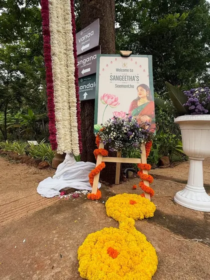 A personalized welcome board for Sangeetha's Seemantham, decorated with fresh flowers. These custom touches make the event feel truly special.
