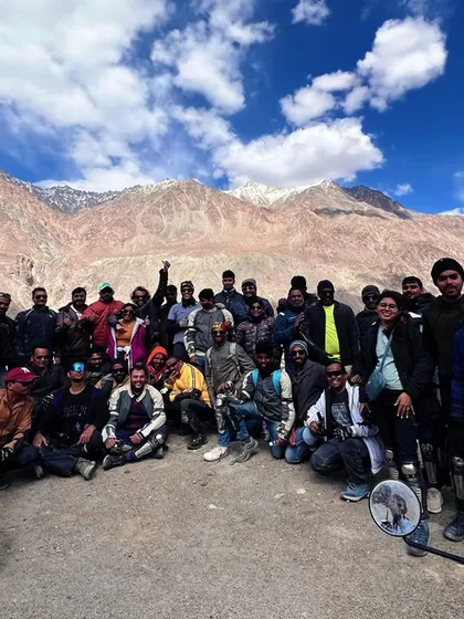 The whole group together against the mighty mountains. You come for the trip, you leave with a family.