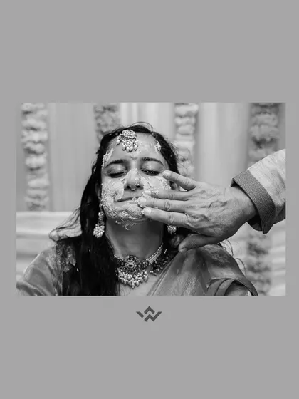 A black and white photo capturing a candid moment from the Haldi ceremony, adding a timeless and artistic feel to the ritual.