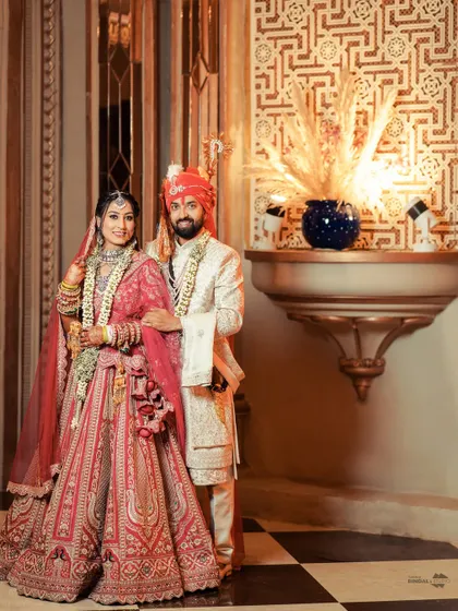 A regal portrait of the couple on their wedding day. The opulent decor and their traditional attire come together to create an image of timeless royal romance.