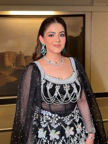 The final look, glammed to perfection. The clean makeup and radiant skin complement her intricate black and silver outfit beautifully.