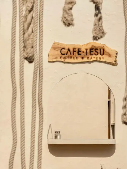 Detail shot of the Cafe Tesu service window, framed by thick ropes that add a nautical, rustic texture to the overall design.