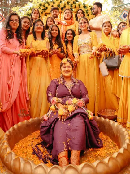 A fantastic group photo of the bride with all her bridesmaids and family during a fun-filled Haldi ceremony.