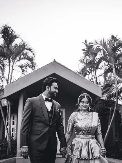 A timeless black and white photo of the couple walking hand-in-hand at their destination wedding. This classic shot highlights their elegant reception attire.