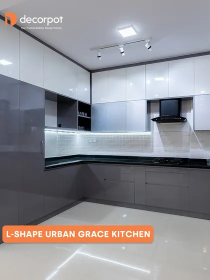 This L-shaped kitchen, named 'Urban Grace', features a sleek two-tone grey and white high-gloss finish. The layout opens up the room, making the space feel larger, while providing plenty of storage and a clean, modern aesthetic.