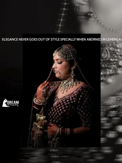 A dramatic black and white portrait of a bride, her face gently lit, with her intricate matha patti and nath on display.