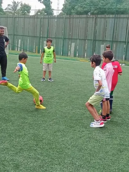 A young player takes a powerful kick during a birthday party game, showing off his skills.