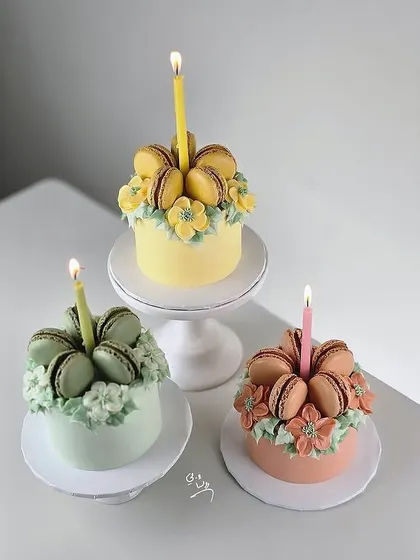 A trio of our macaron-topped floral cakes, showcasing different color combinations.