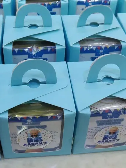 These 'Boss Baby' themed return gift boxes are a great budget-friendly option. They come with a handle for easy carrying and a window to show the treats inside, all personalized for the event.