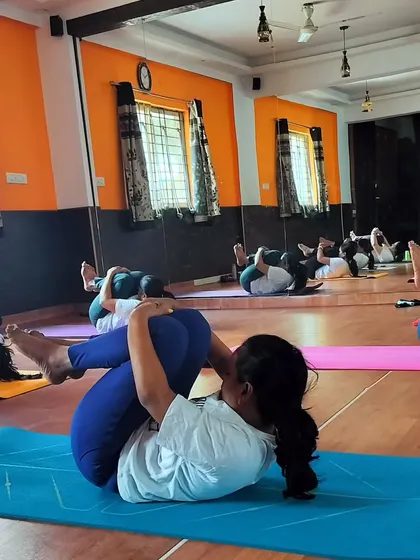 Here, the class is in Pavanmuktasana, the wind-relieving pose. It is a simple but effective asana for releasing tension in the lower back and improving digestive health.