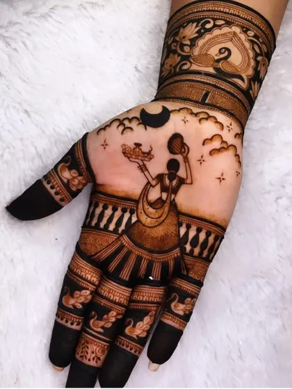 A beautiful depiction of a woman on a terrace celebrating Karwa Chauth, with the moon in the sky. The fingers are fully colored for a traditional and dark henna stain.