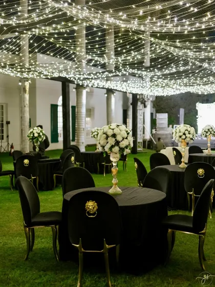 Elegant black and white themed guest seating under the starry fairy light canopy, perfect for a glamorous outdoor Sangeet.