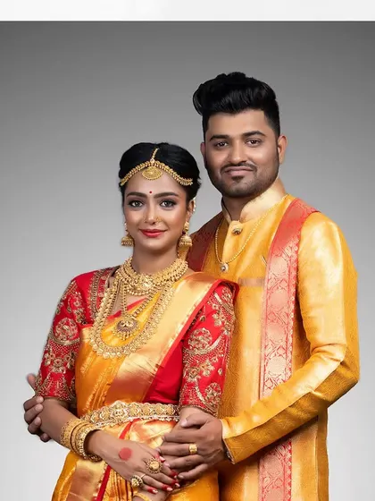 The complete couple's look: her yellow and red saree is perfectly matched with his golden silk kurta.