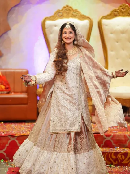 A full-length shot of the bride, capturing her radiant smile and the beautiful flow of her traditional engagement outfit.