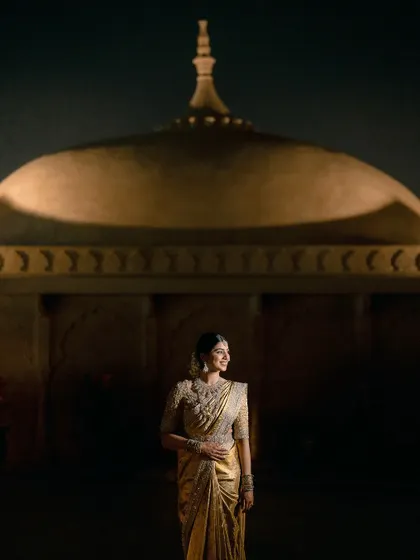 A stunning portrait of the bride against the backdrop of the illuminated palace dome at night.