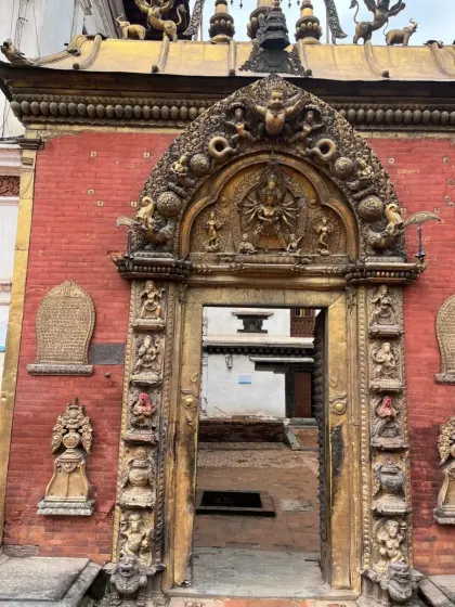 An ornate golden gate, the entrance to a temple courtyard in Bhaktapur. It stands as a testament to the incredible skill of Newar artisans.