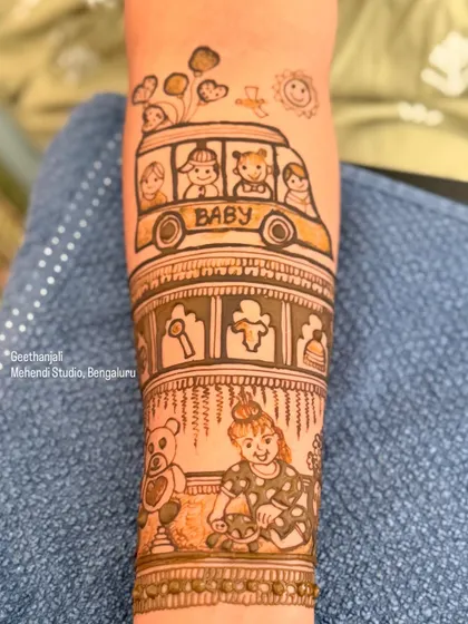 A close up of a custom baby shower mehendi. This design features a 'baby bus', a teddy bear, and a little girl playing, telling a sweet story of childhood.