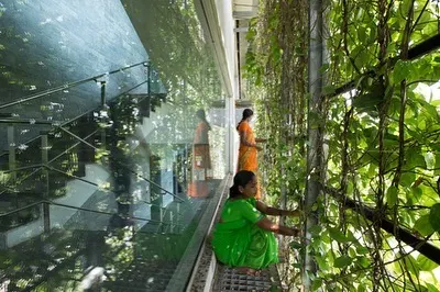 Here, gardeners tend to the living facade of the KMC Headquarters. The design incorporates catwalks for easy maintenance, ensuring the health and beauty of the green veil that defines the building.