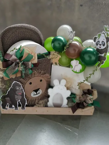 A creative jungle-themed gift arrangement featuring a mini balloon arch and adorable animal figures. This hamper is a playful and imaginative way to welcome a new baby.
