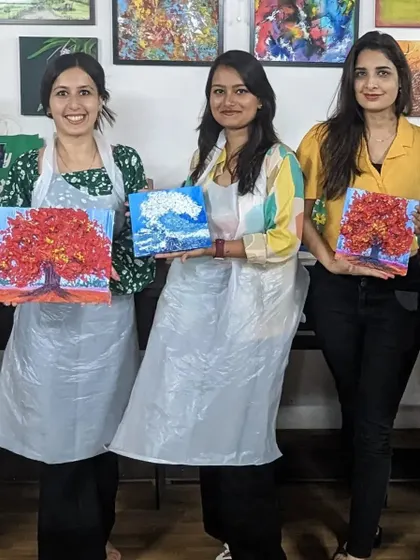 A group of friends showing off their beautiful texture paintings of autumn trees and ocean waves.