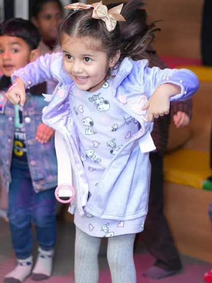 A young girl dances with joy, fully immersed in the party atmosphere.