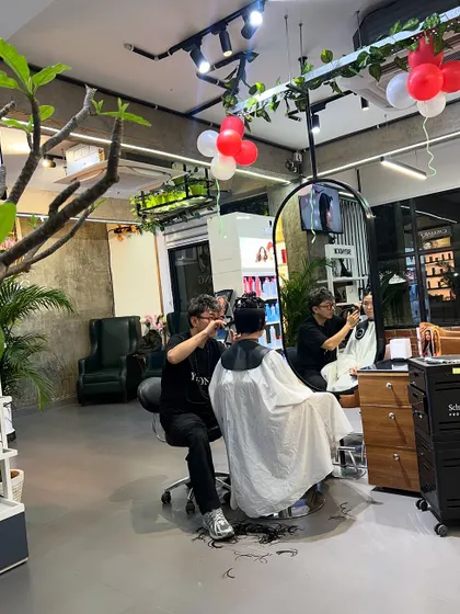 Hairstyling is an art. This image captures a stylist focused on a haircut, reflecting the creativity and skill that goes into every service.