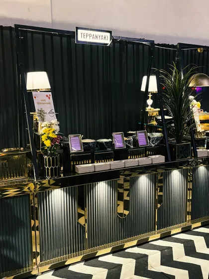A full view of our live Teppanyaki station, elegantly designed with black and gold accents. This setup is perfect for adding a touch of Japanese culinary theatre to your corporate event.