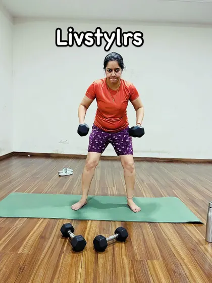 A client performs a squat with dumbbells, a foundational strength-building exercise. Her strong form is a result of consistent practice and guidance.