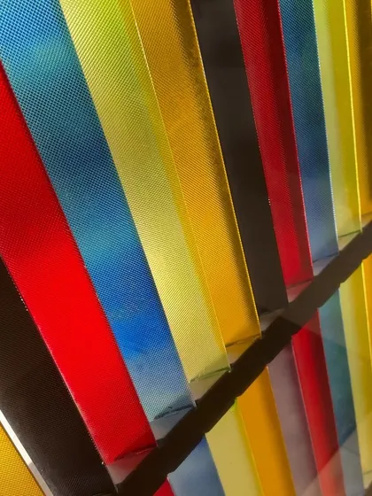 A close-up of the textured, colored glass panels, showing how light interacts with the different hues to create a dynamic and playful effect.
