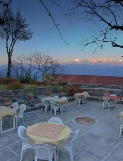The outdoor terrace seating area at dusk, offering breathtaking views of the surrounding Himalayan peaks.