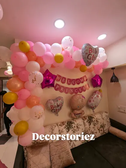 A closer look at the pink balloon wall decoration for a 'Welcome Princess' celebration. It includes 'Baby Girl' foil balloons and a mix of soft pinks, whites, and gold.