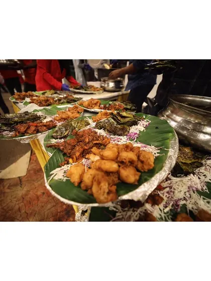 Bringing the world to your table. This image shows a buffet line with starters served on banana leaves, showcasing a traditional yet elegant setup for a large gathering.