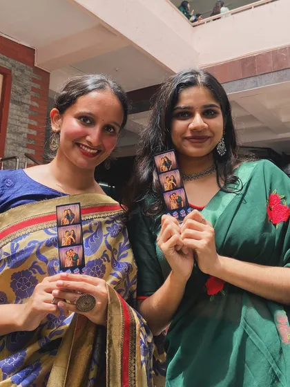 A group of friends holding up their matching photo strips from Mount Carmel's Ethnic Day.