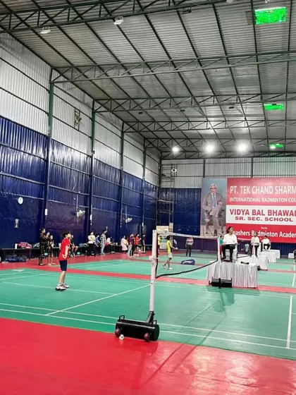 A wide view of our well-lit, international standard indoor courts during a tournament at the academy.