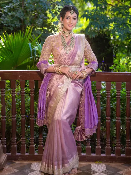 A full-length shot of the stunning lilac South Indian look, showing the graceful drape and how the makeup creates an overall royal feel.