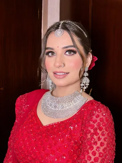 A close-up of Anjali's radiant smile. Her makeup is fresh and dewy, with a focus on skin that looks healthy and glowing. The simple bindi completes the look.