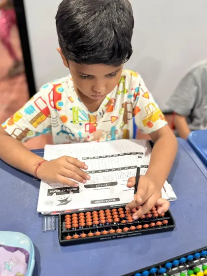 This student is using his abacus to work through a problem. The physical act of moving the beads helps reinforce numerical concepts.