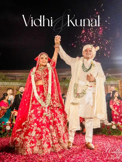 Pure celebration. The bride and groom raise their hands in triumph after the varmala ceremony, a perfect candid shot filled with happiness and the promise of a shared future.