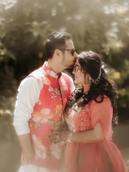 A tender kiss on the forehead. This classic romantic gesture, captured in soft, natural light, creates a timeless and emotional portrait of the couple.