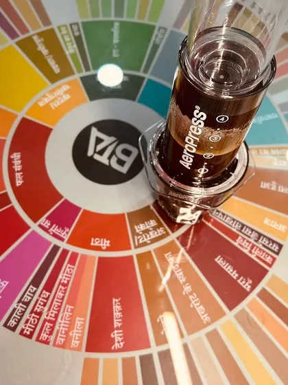 A shot of our Hindi script coffee flavor wheel next to an Aeropress. We created this wheel to make coffee more inclusive and accessible, breaking language barriers.
