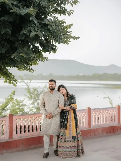 A quiet, peaceful portrait of the couple by the lake, with the bride resting her head on the groom's shoulder.