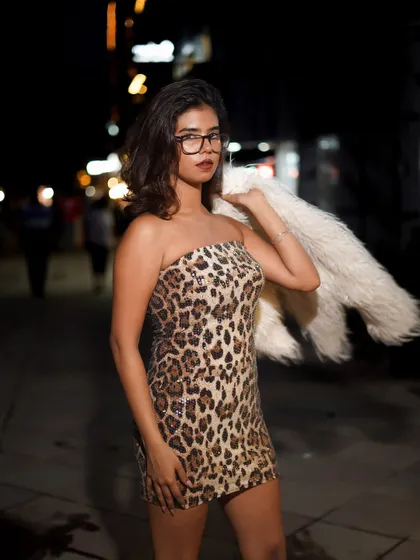 A powerful portrait using flash to illuminate the model against the dark street. The glasses add a smart, chic element to the wild leopard print.