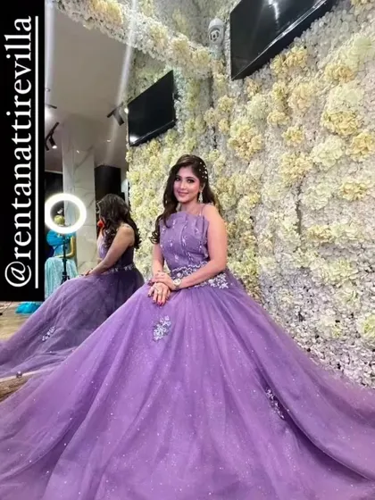 A client trying on a lovely lavender gown in my studio, sitting in front of a flower wall. It's a perfect spot to see how you'll look in photos.