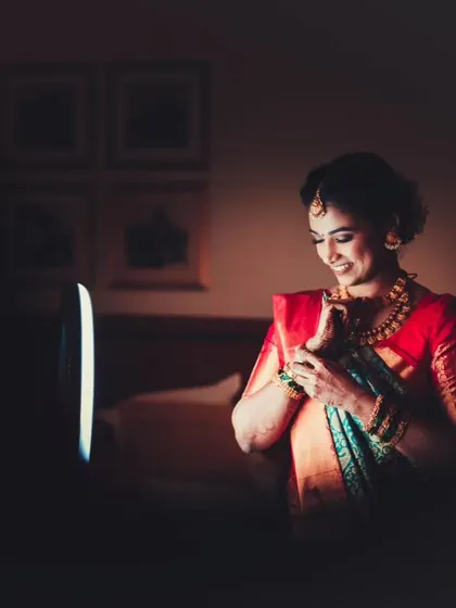 A beautifully lit shot of the bride smiling as she gets ready, captured with a sense of intimacy and warmth.