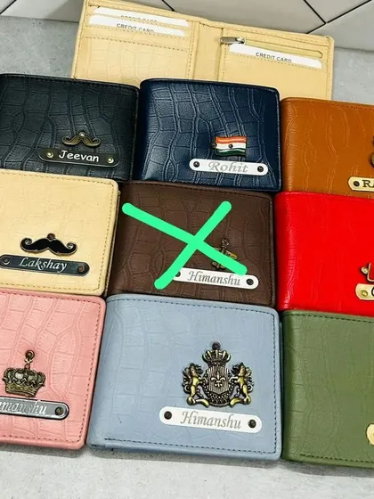 A collection of my crocodile-textured wallets in various colors, each customized with different names and charms like the Indian flag, a music note, or a crown.