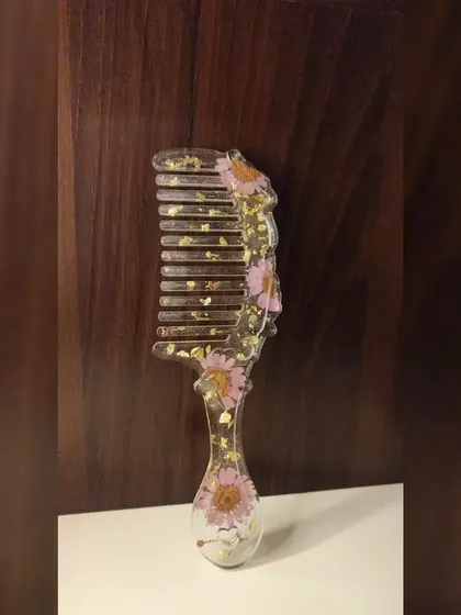 I also make fun and functional accessories like this floral resin comb. This piece features pretty pink daisy flowers and a sprinkle of gold flakes, turning an everyday item into a unique piece of art.