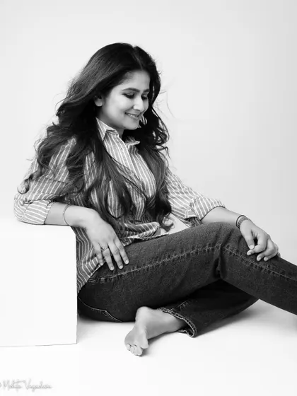 A candid black and white moment from the same session. Looking down with a soft smile, this image feels intimate and authentic, capturing a quiet moment of reflection.